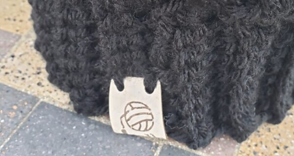 Product image of Black baby hat with colored poof ball 6-12 month size