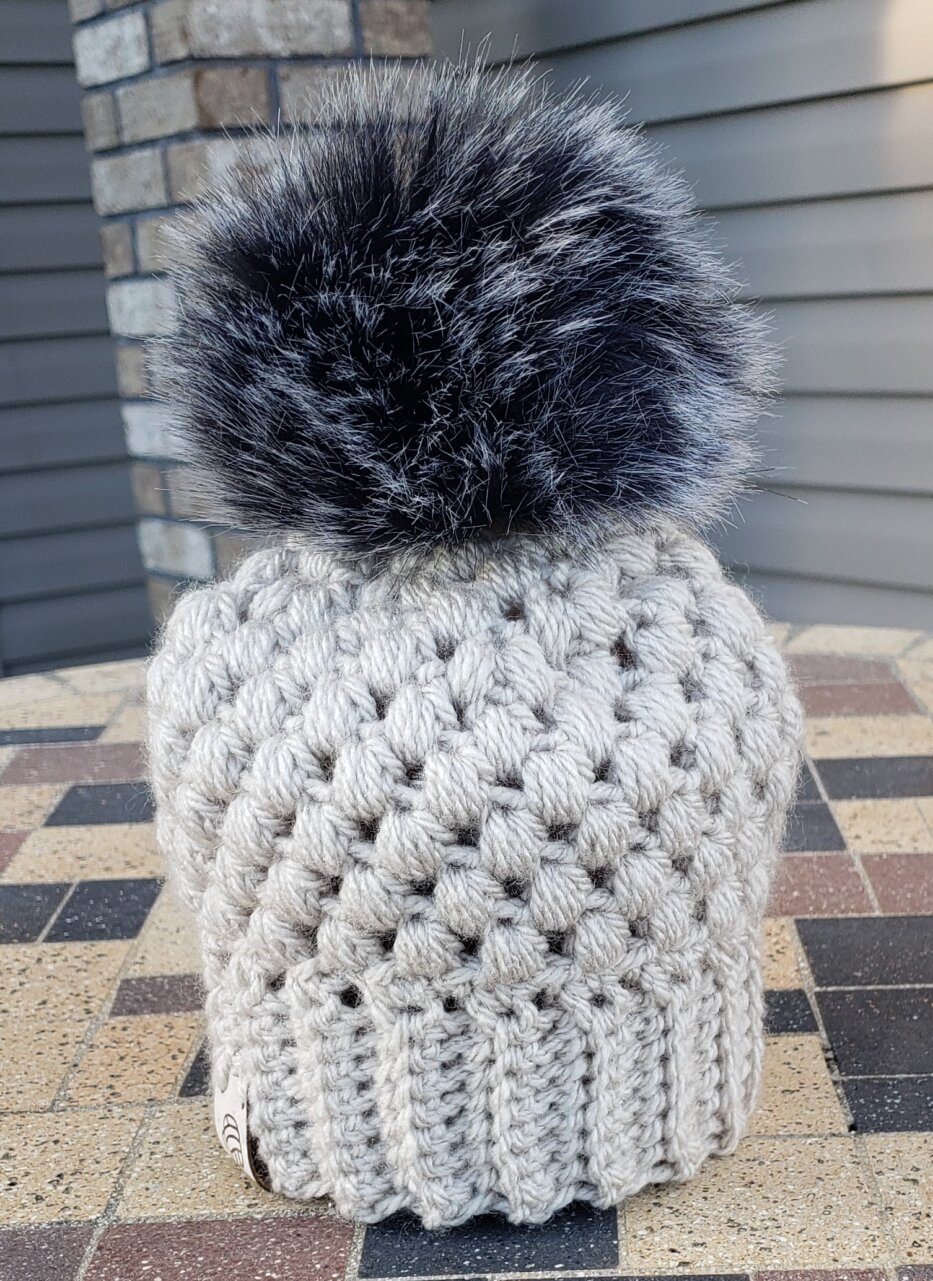Light cream hat with black/brown poof 